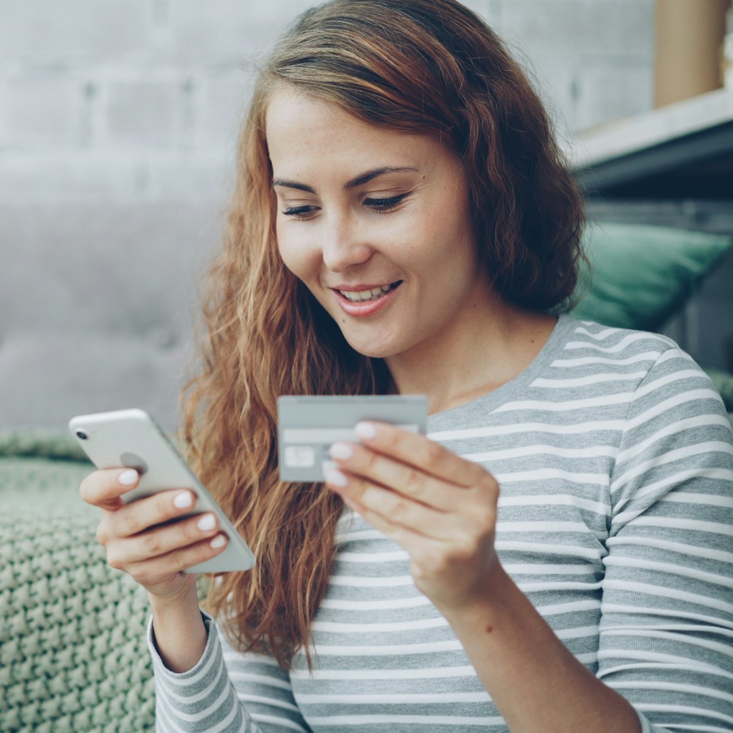 Smiling woman with her card and phone